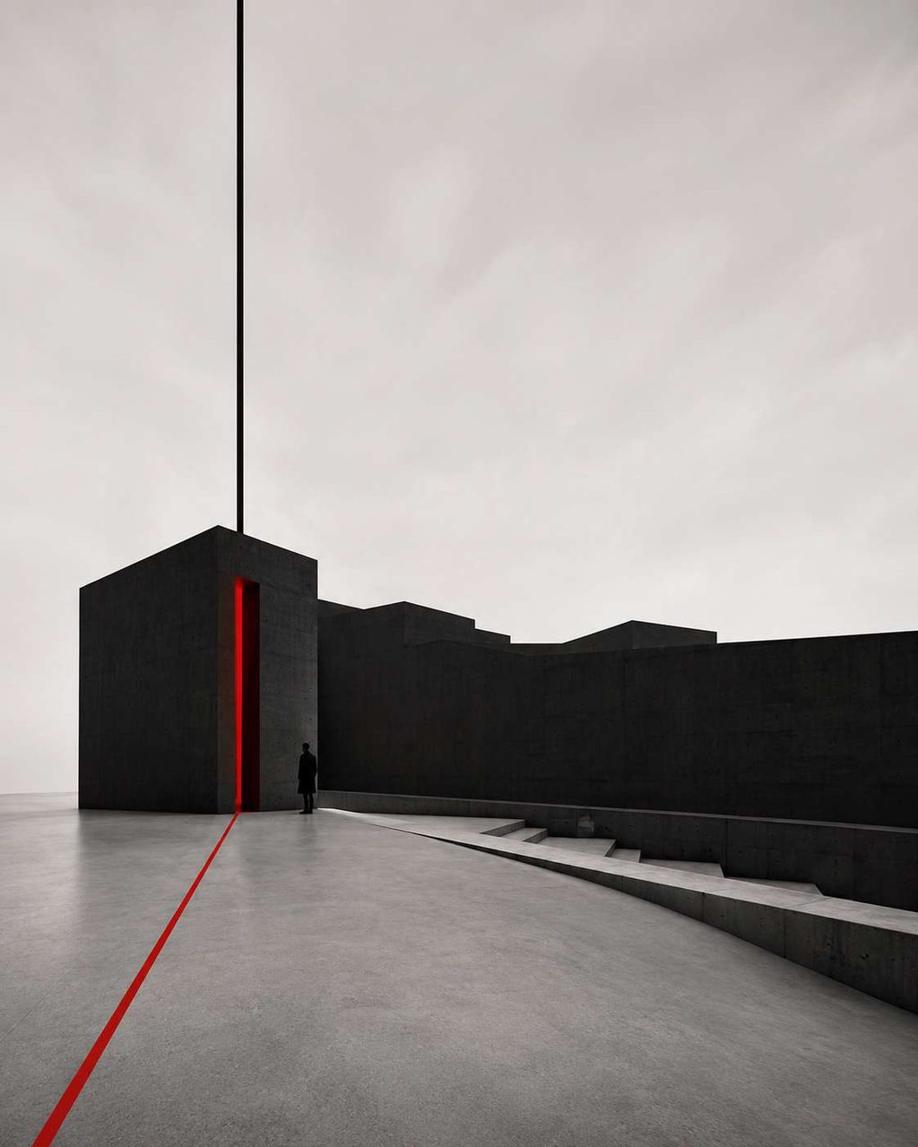 A long concrete causeway running out to a pale horizon, traced by a single red line.