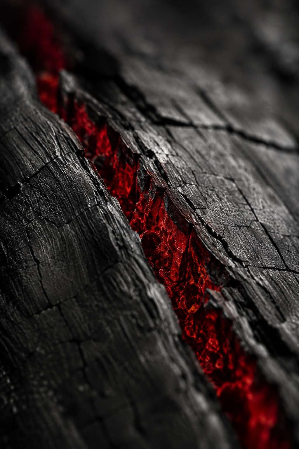Charred timber split along a fault line, a deep red glow inside the crack.